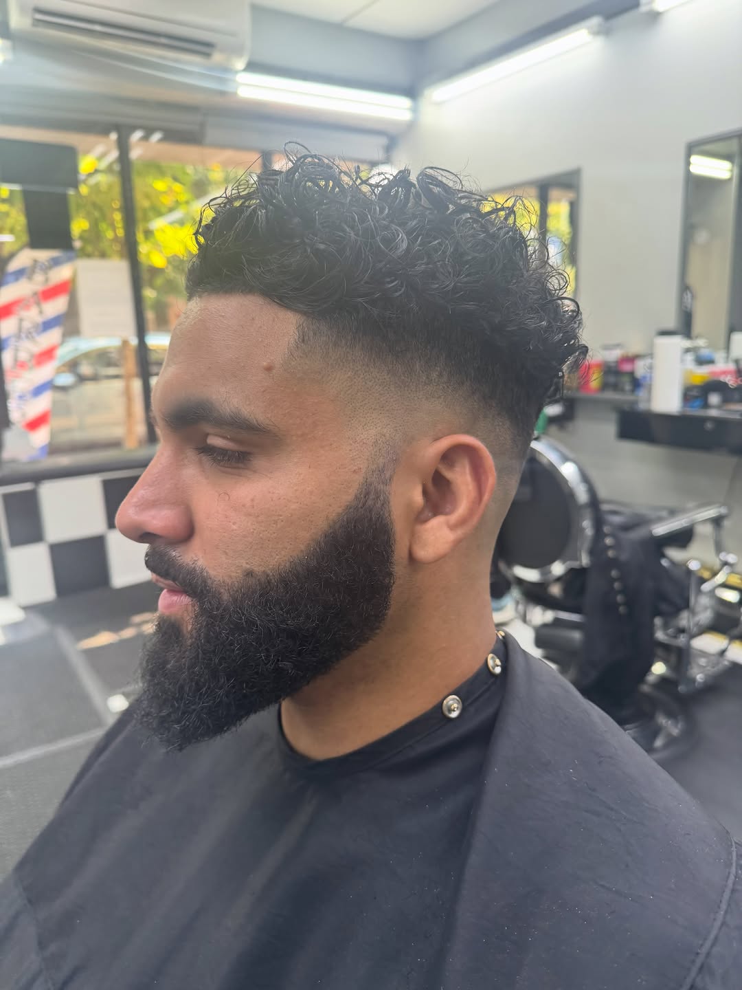 Curly top with a fade cut at Sunset All Stars